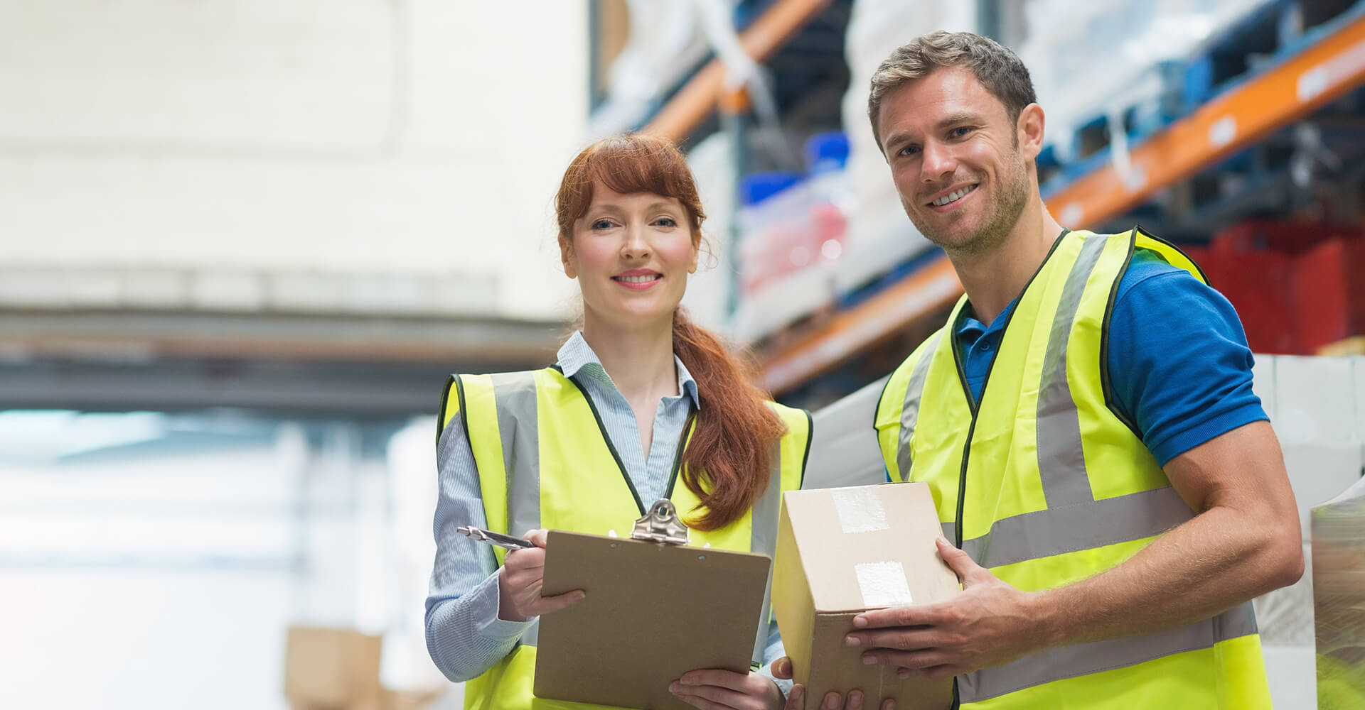 Supply chain management professionals working on logistics together in high visibility vests