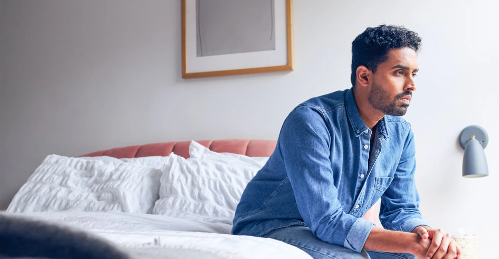 a man sitting on a bed blue Monday 2023