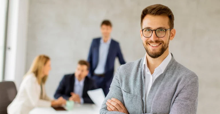 a man with glasses and a beard smiling business manager
