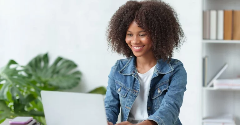 a woman smiling at a laptop career change