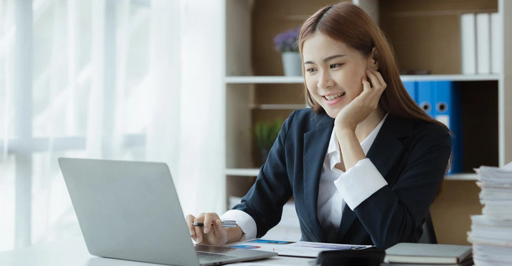 a woman sitting at a desk with a laptop career in finance