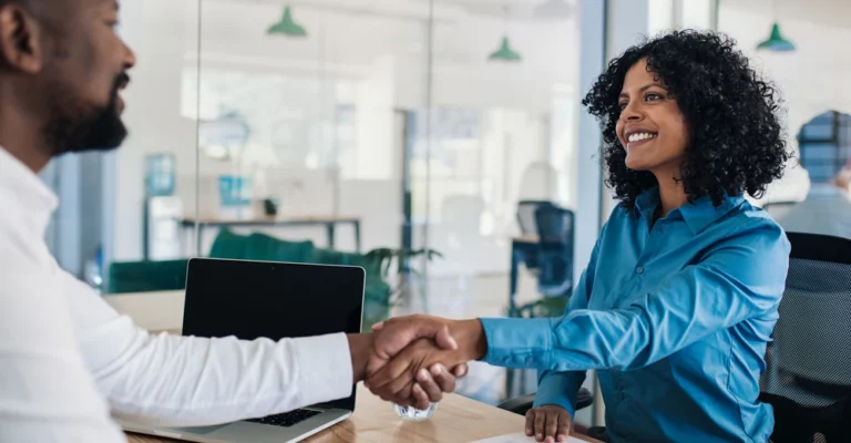 a woman shaking hands with a man career in human resources
