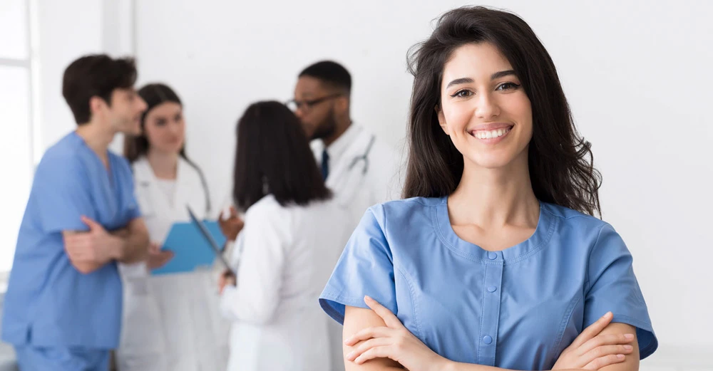 a woman smiling with her arms crossed medical office assistant
