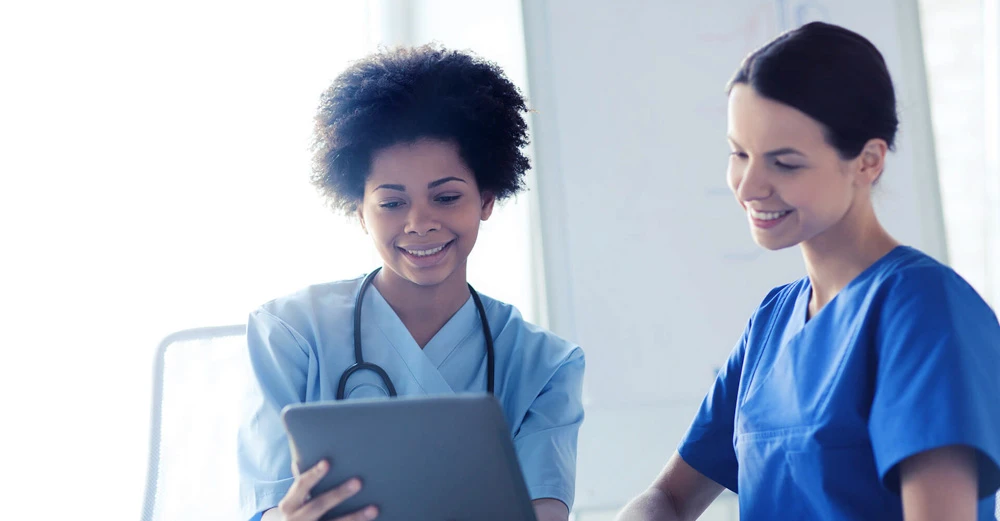 a few medical professionals looking at a tablet medical office assistant
