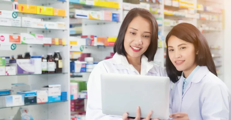 a couple of women in white coats looking at a laptop practicum Placement