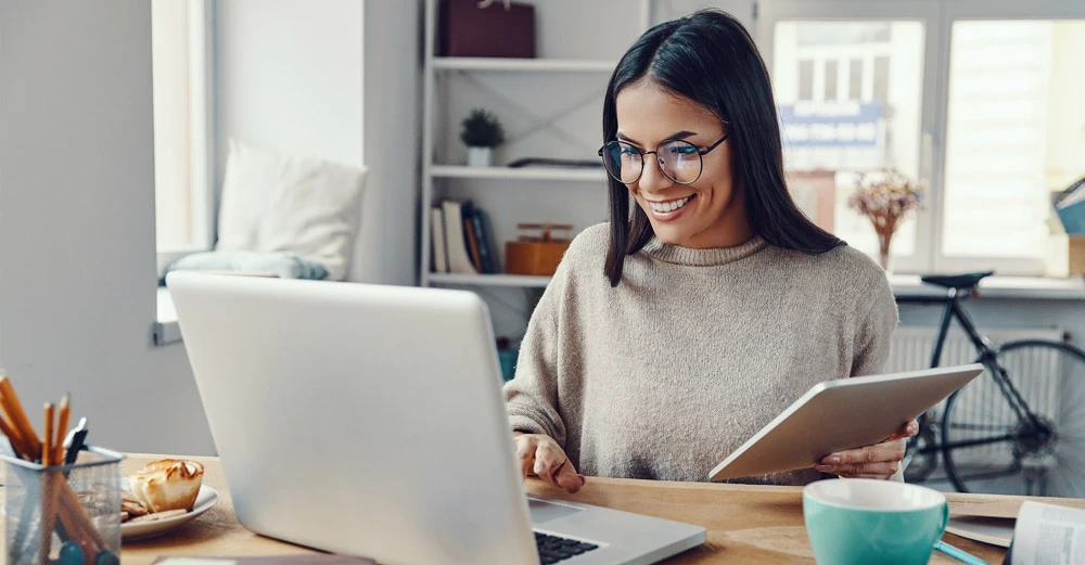 a woman smiling at a laptop