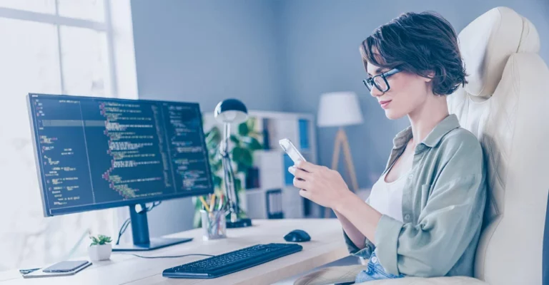 A developer working on code and reviewing a mobile layout.