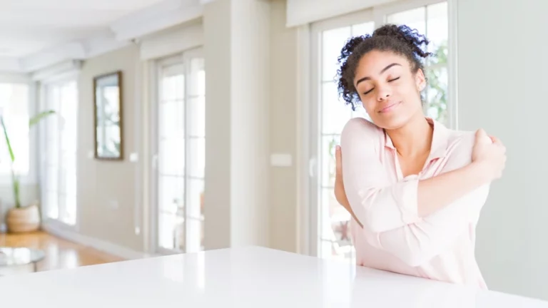 woman practicing self-care by hugging herself