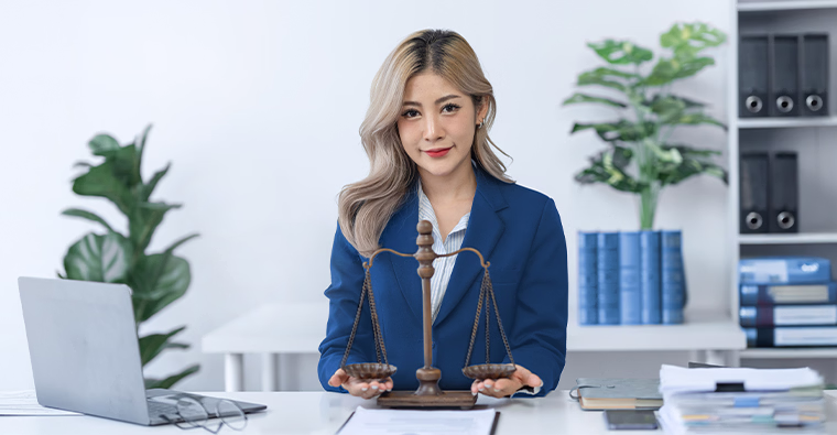Young woman smiling while working in a legal office, representing an entry-level legal assistant career opportunity.