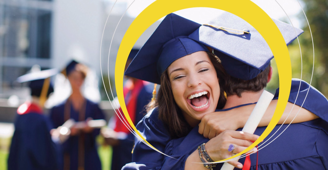 A Sundance College graduate celebrating her graduation, hugging her friend and holding her diploma.