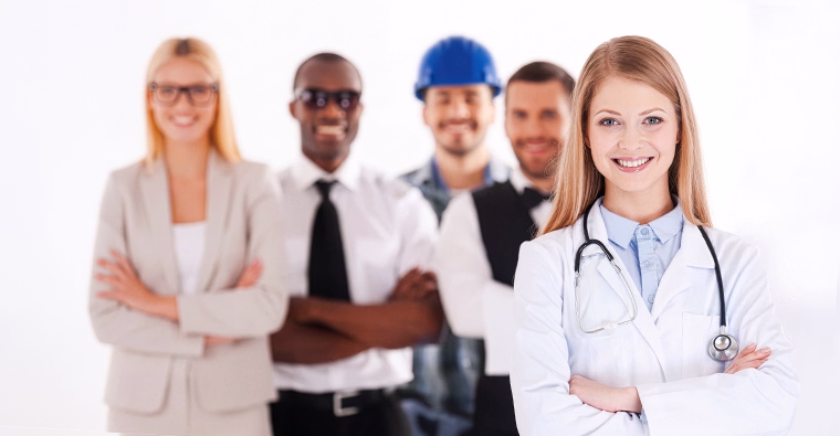 Confident medical office administrator in scrubs with arms crossed, standing in front of a group of people from different professional industries.